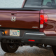 A photo of the tailgate on a burgundy Honda Ridgeline truck.